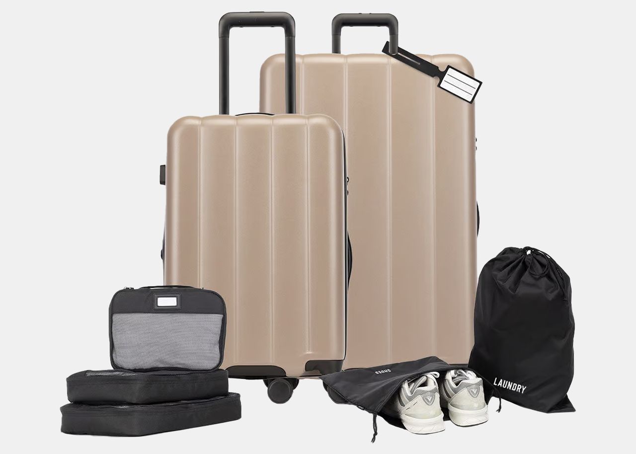 two tan suitcases with smaller black packing accessories