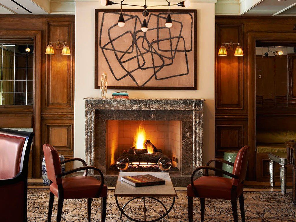 Image may contain: Fireplace, Indoors, Hearth, Furniture, and Chair