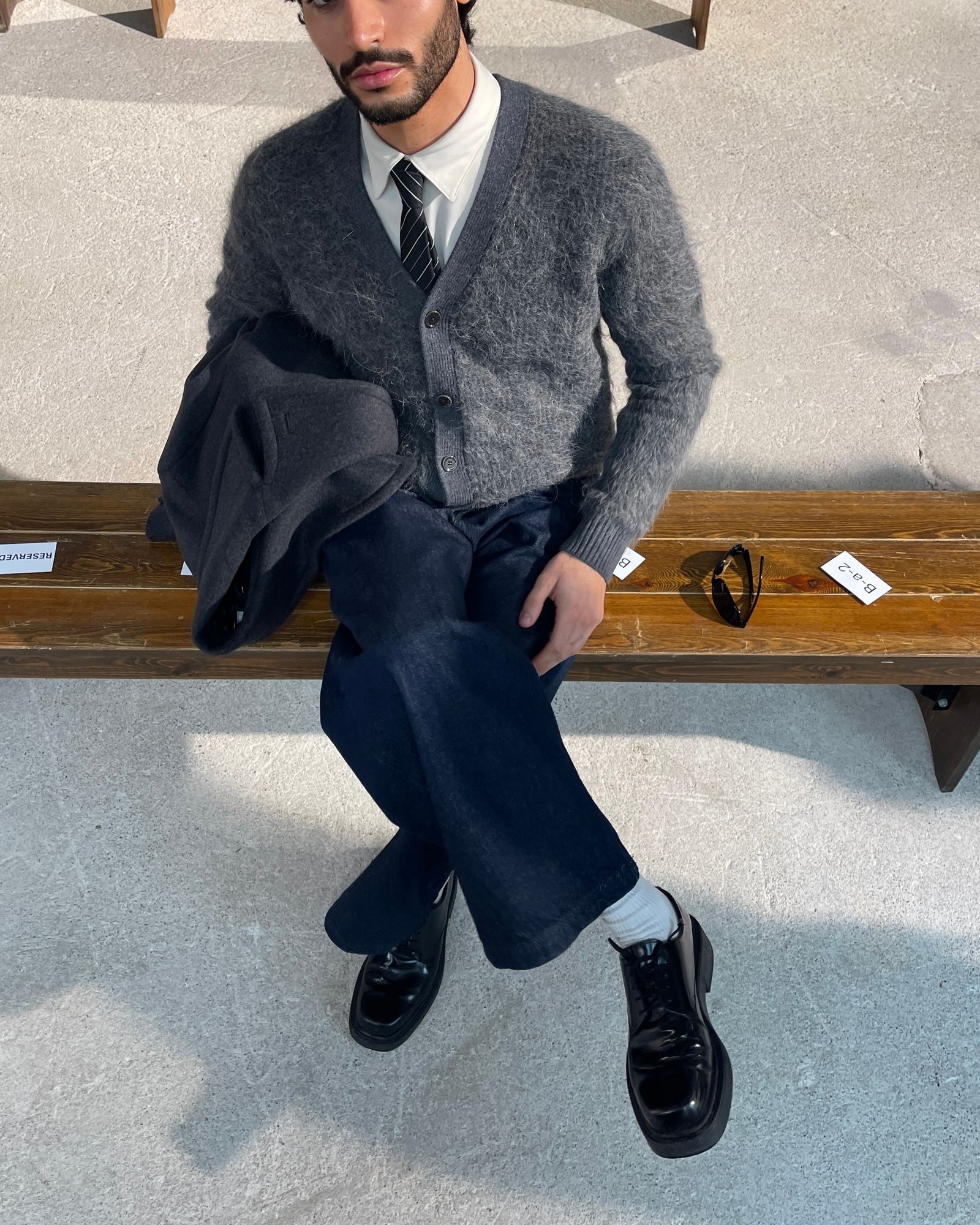 Image may contain Toni Mahfud Person Sitting Clothing Pants Adult and Coat