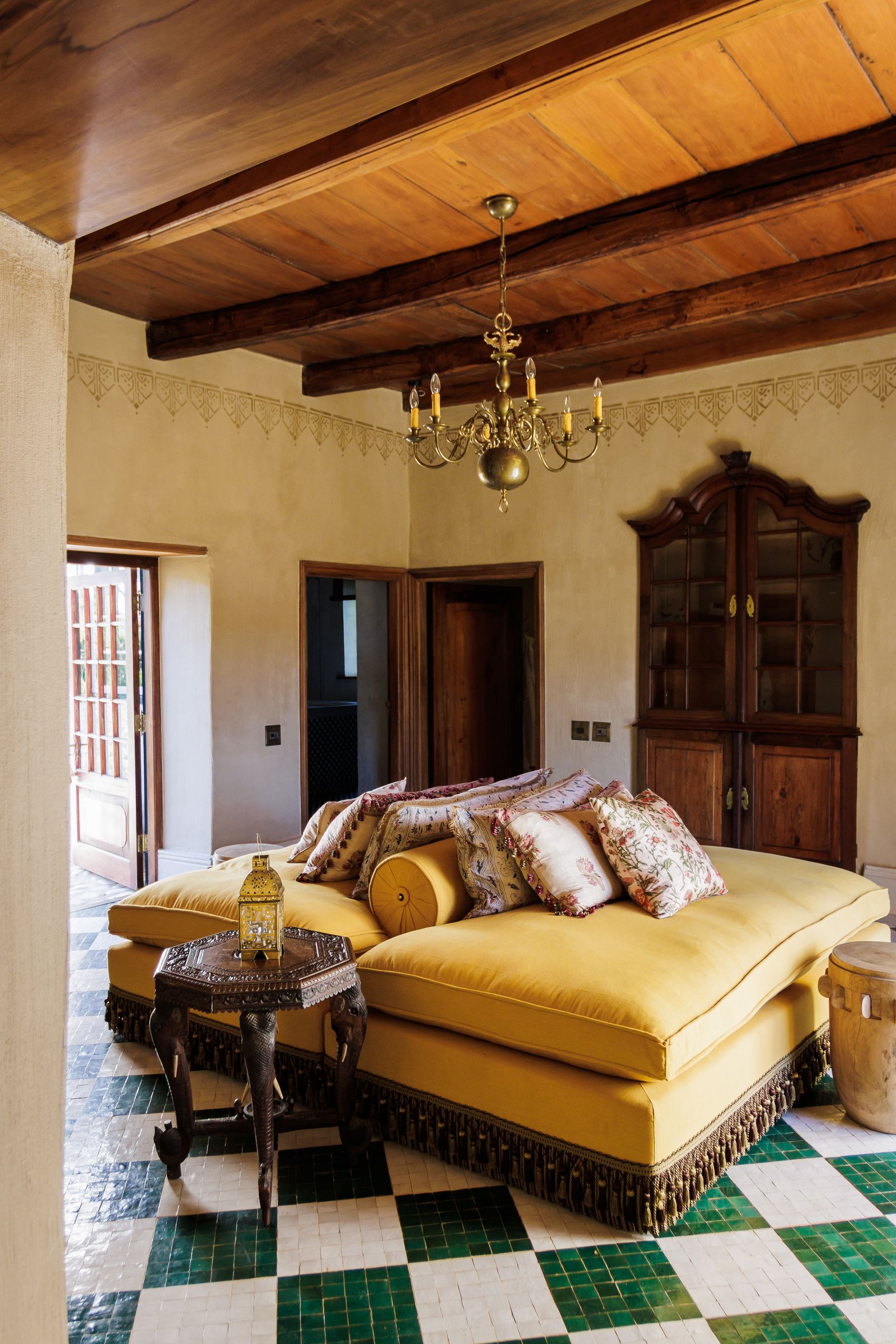 Image may contain Indoors Interior Design Lamp Chandelier Home Decor Floor Wood Flooring Couch and Furniture