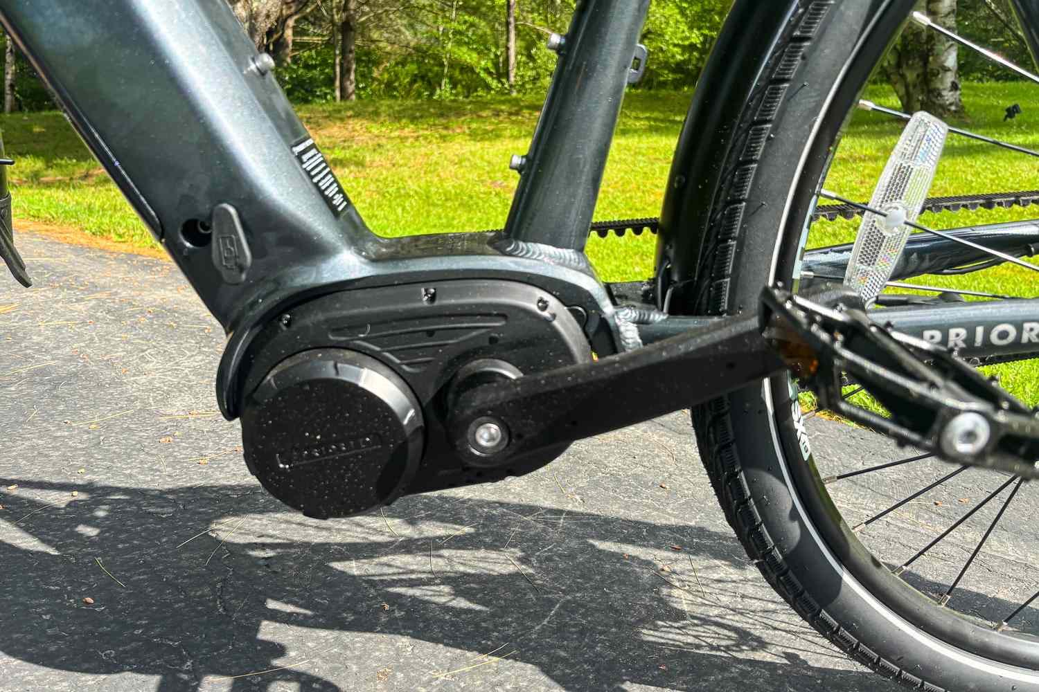 Close-up of a Priority electric bike motor and pedal system on a paved path