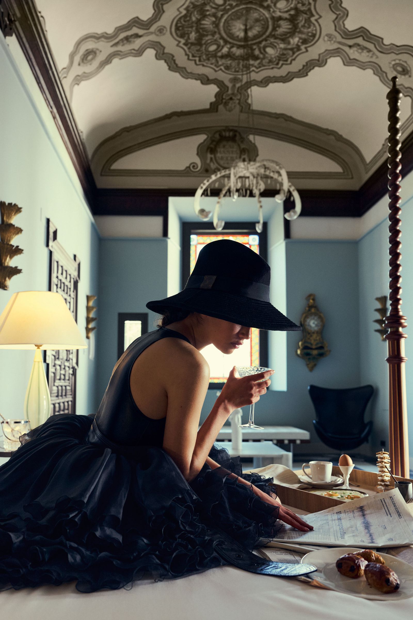 Image may contain Lamp Adult Person Cup Clothing Hat Dress Plate Face Head Photography Portrait and Architecture