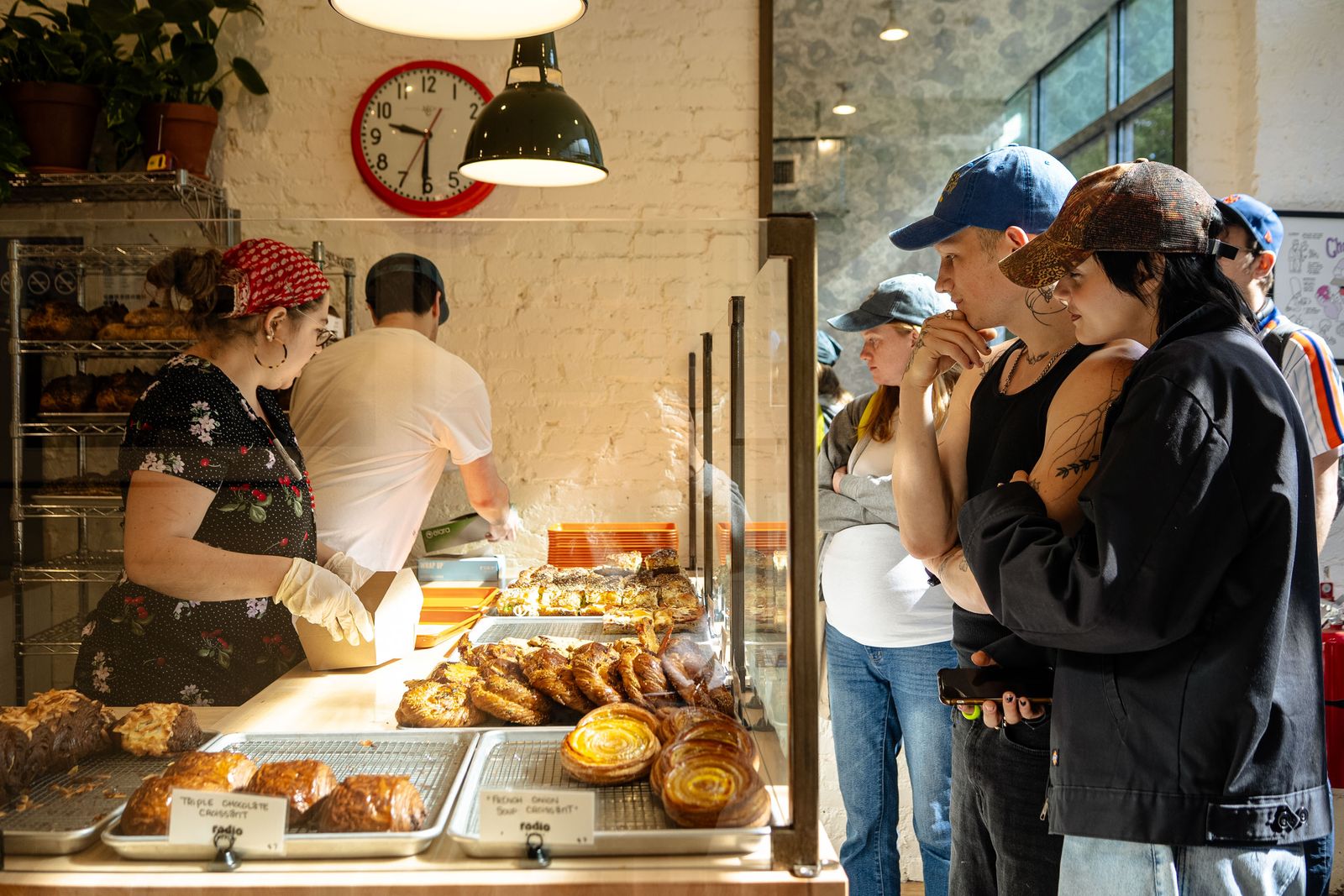 People standing in line while waiting to order inside of a bakery