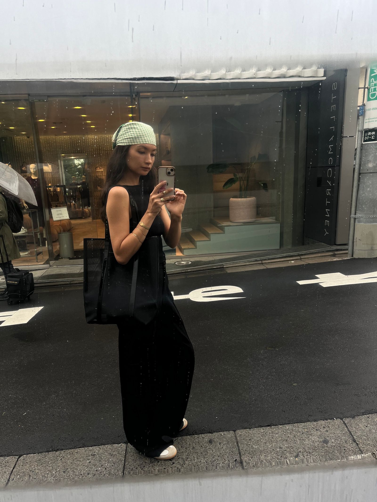 Image may contain Pedestrian Person Teen Plant Clothing Hat Electronics Mobile Phone Phone Accessories and Bag