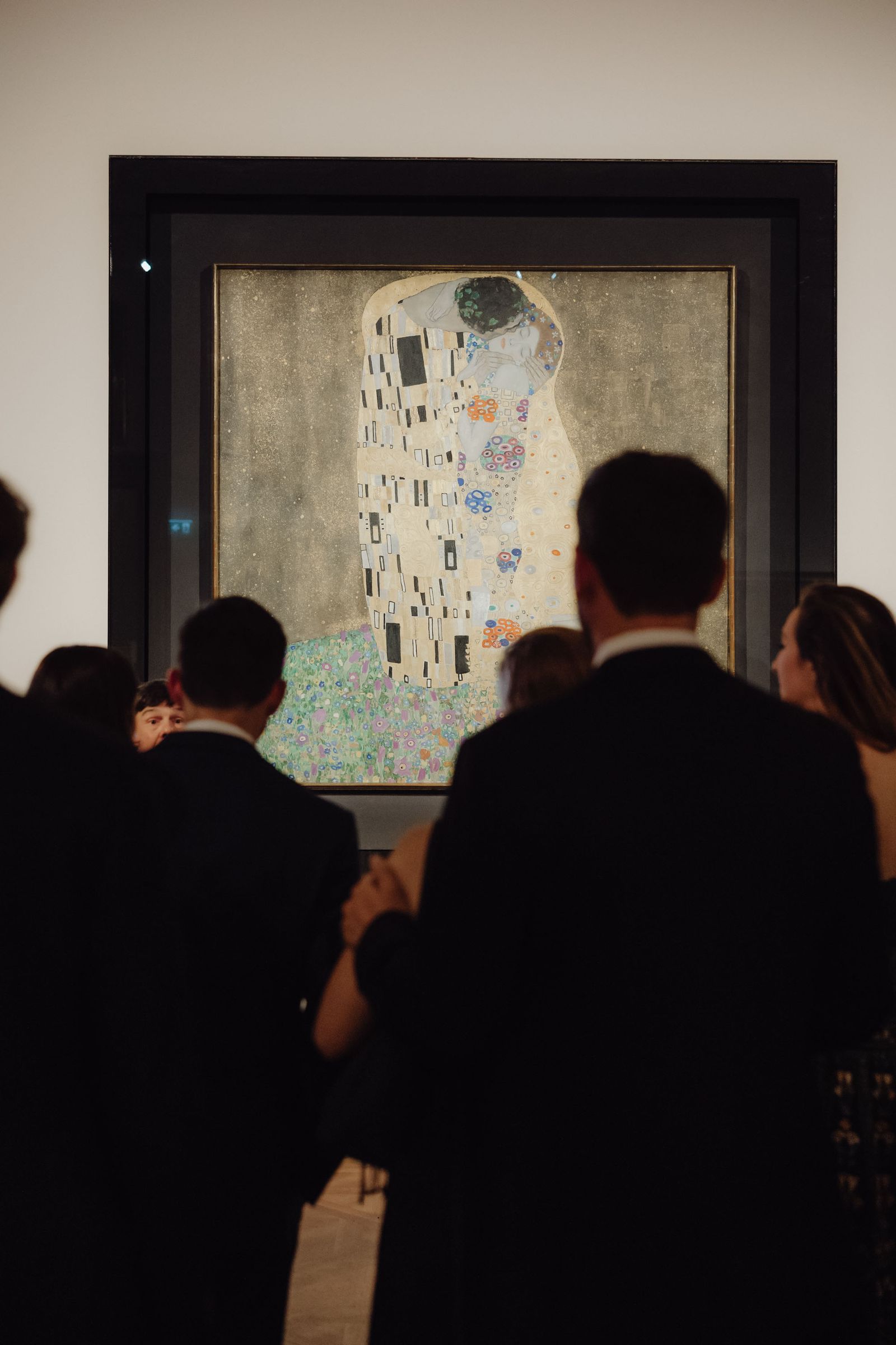 People looking at The Kiss painting by Gustav Klimpt