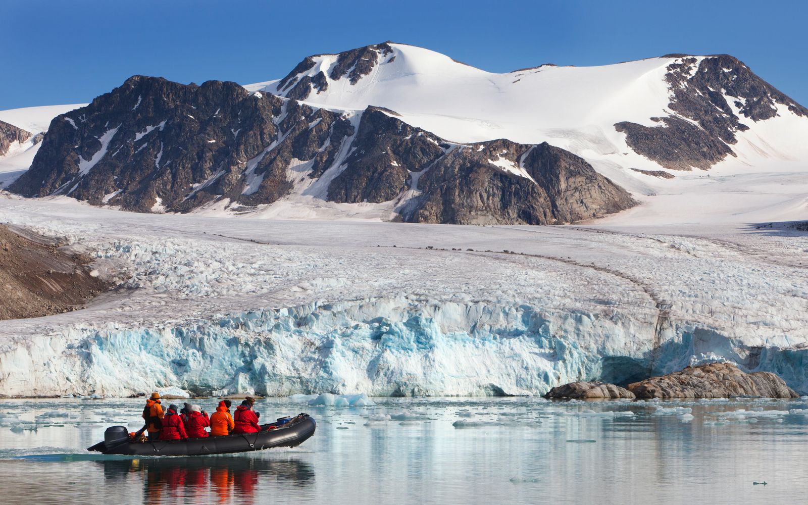 Arctic tourists cruising glacier in Svalbard